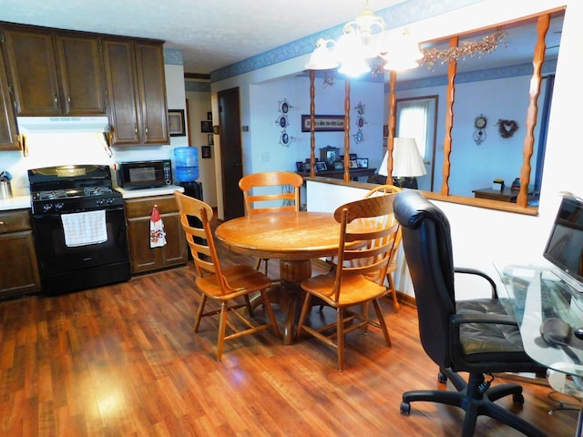 dining room with dark wood-type flooring and an inviting chandelier