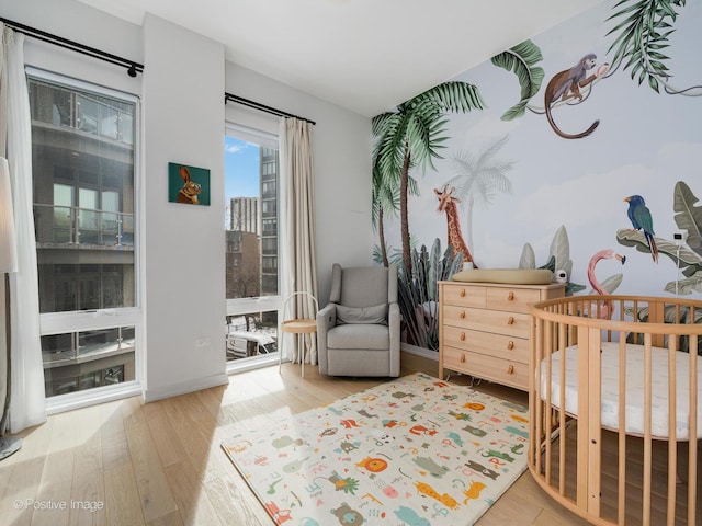 bedroom featuring a crib and hardwood / wood-style flooring