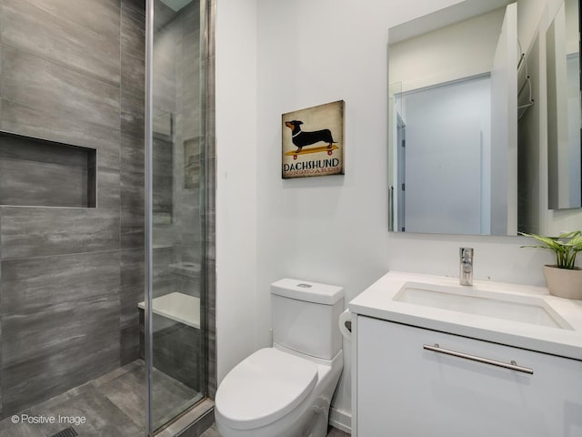 bathroom featuring a stall shower, toilet, and vanity