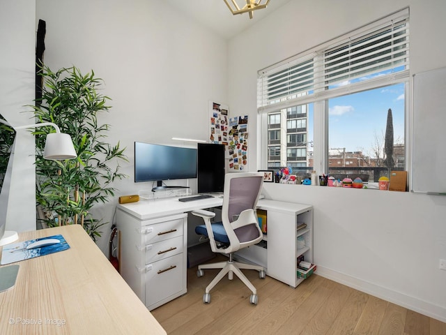 home office with baseboards and light wood-type flooring