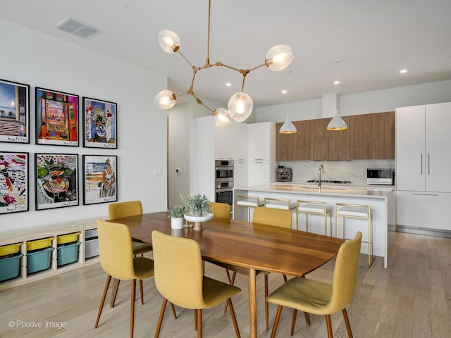 dining space featuring recessed lighting, visible vents, and light wood finished floors