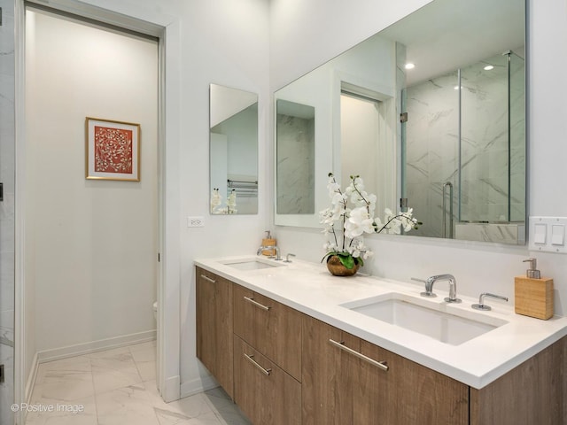 full bath with a sink, a marble finish shower, baseboards, and marble finish floor