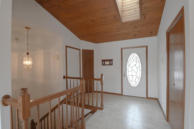 entryway featuring wooden ceiling, vaulted ceiling, and baseboards