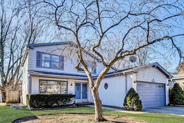 traditional home featuring a front yard, driveway, and an attached garage