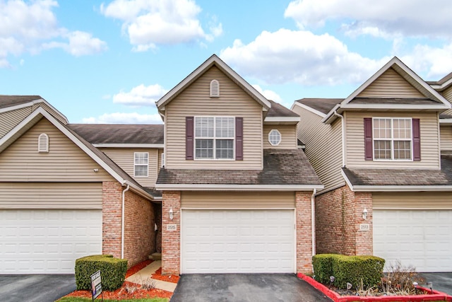 view of property with driveway and brick siding