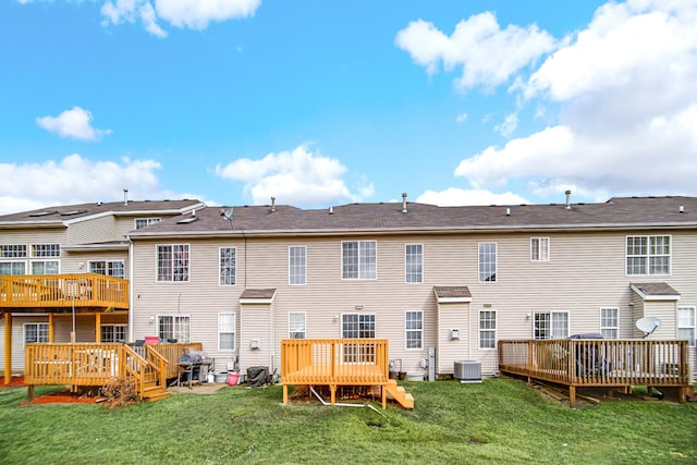 rear view of property featuring cooling unit, a lawn, and a wooden deck