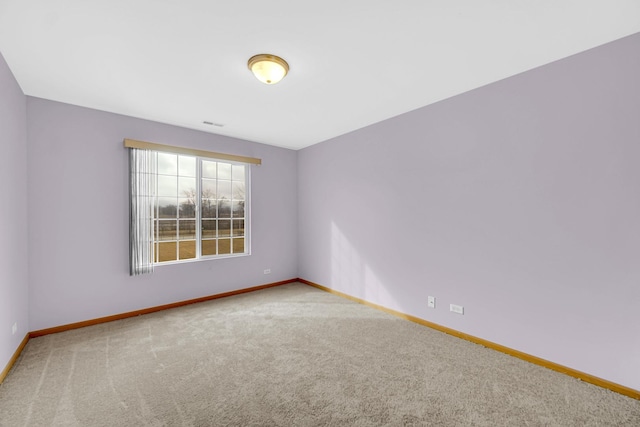 empty room featuring carpet flooring, visible vents, and baseboards