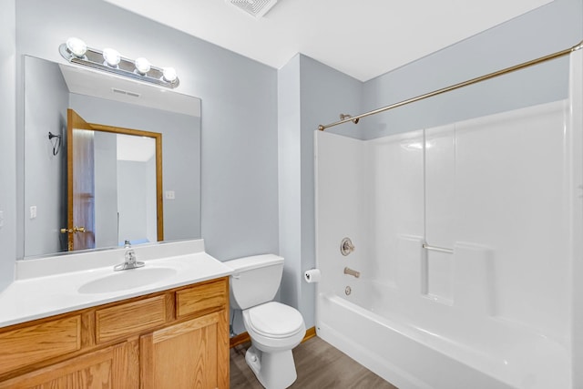 bathroom featuring visible vents, toilet, wood finished floors, vanity, and washtub / shower combination