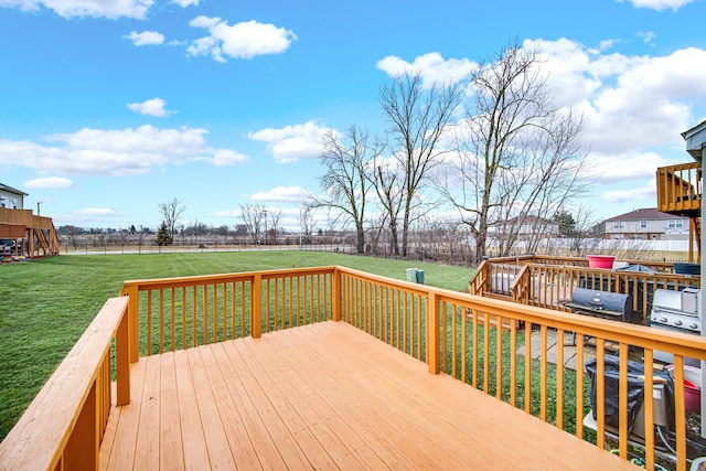 wooden deck with a yard and a grill