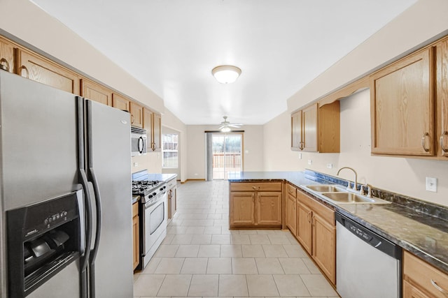 kitchen featuring light tile patterned flooring, a peninsula, a sink, a ceiling fan, and appliances with stainless steel finishes