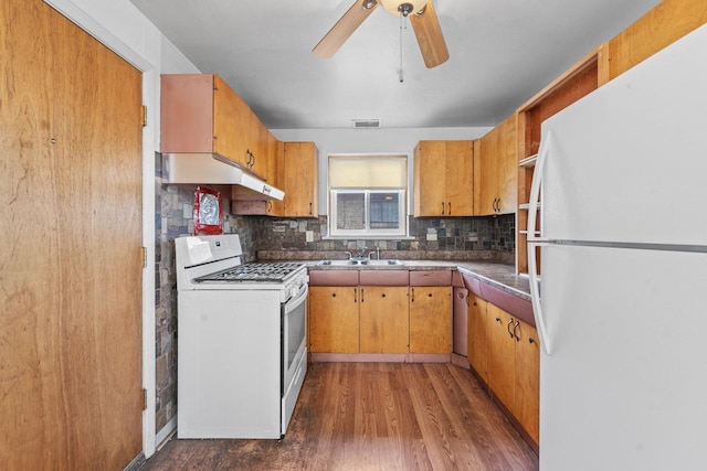 kitchen with white appliances, tasteful backsplash, visible vents, dark wood-type flooring, and a sink