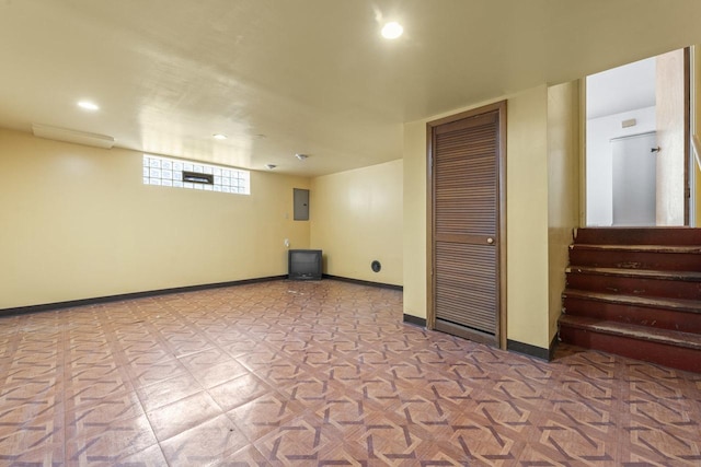 basement featuring recessed lighting, electric panel, baseboards, and stairs