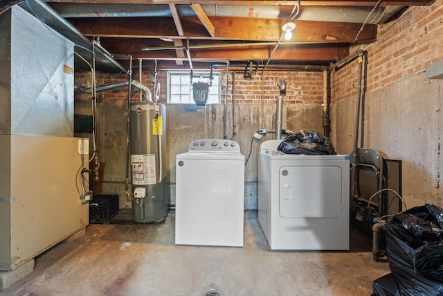 laundry area featuring gas water heater, washing machine and dryer, brick wall, laundry area, and heating unit