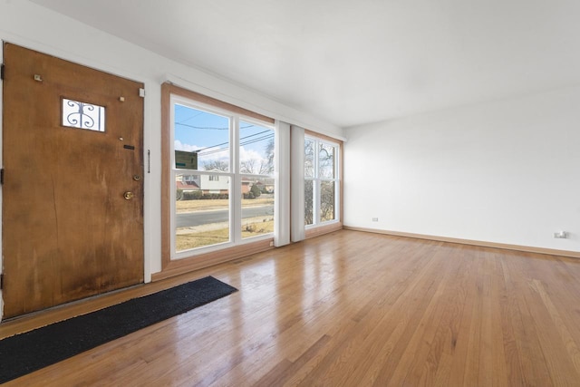 spare room with baseboards and wood finished floors