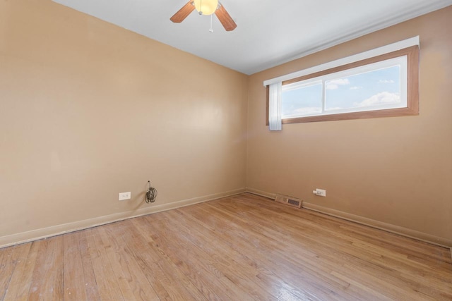 spare room with visible vents, ceiling fan, baseboards, and wood finished floors