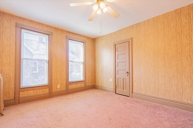 spare room featuring plenty of natural light, ceiling fan, and carpet flooring