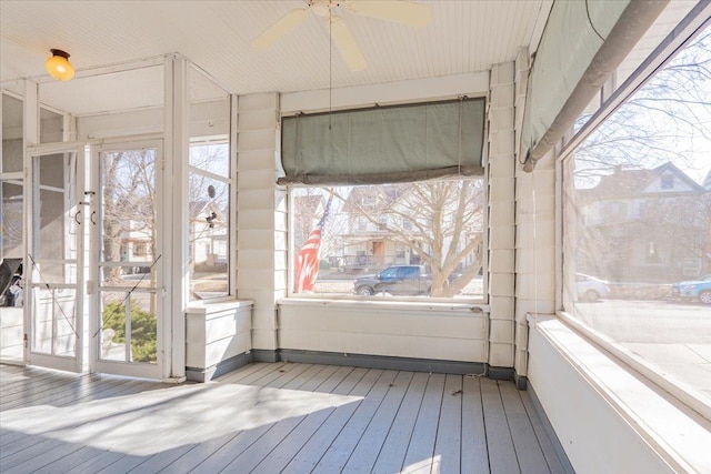 unfurnished sunroom featuring a ceiling fan