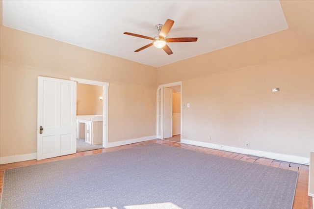 empty room with ceiling fan, baseboards, and wood finished floors