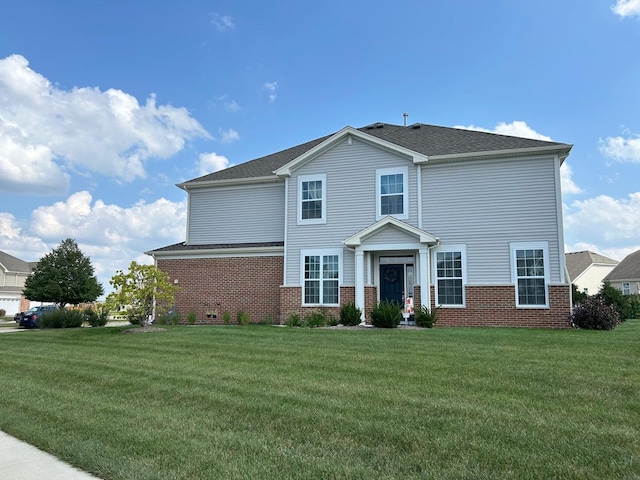 traditional-style home with brick siding, a front lawn, and a shingled roof