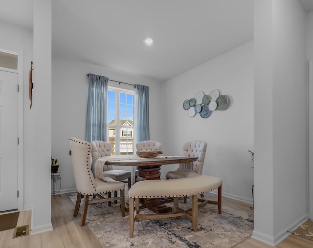 dining room featuring light wood finished floors and baseboards