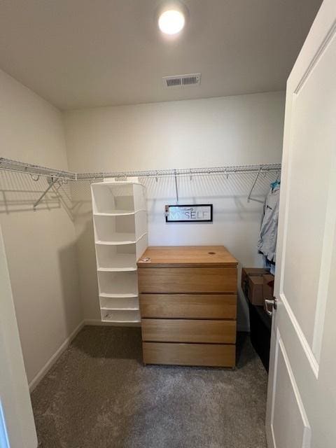 walk in closet featuring dark carpet and visible vents