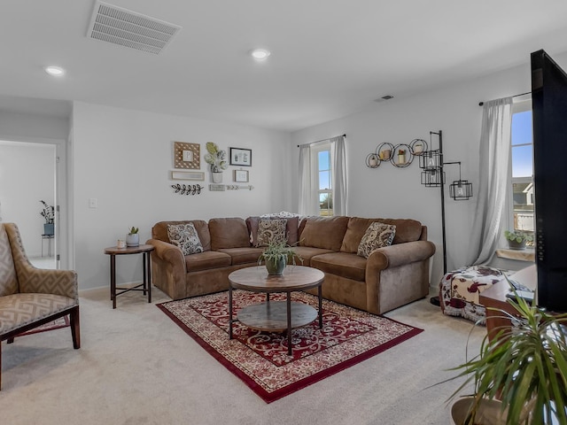 living room with recessed lighting, visible vents, and light colored carpet