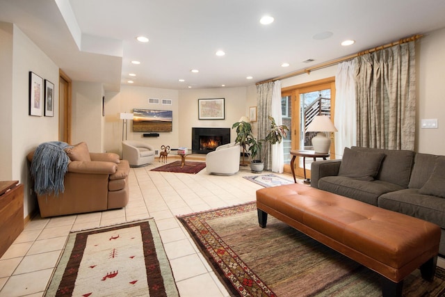 living area featuring a warm lit fireplace, recessed lighting, visible vents, and light tile patterned flooring