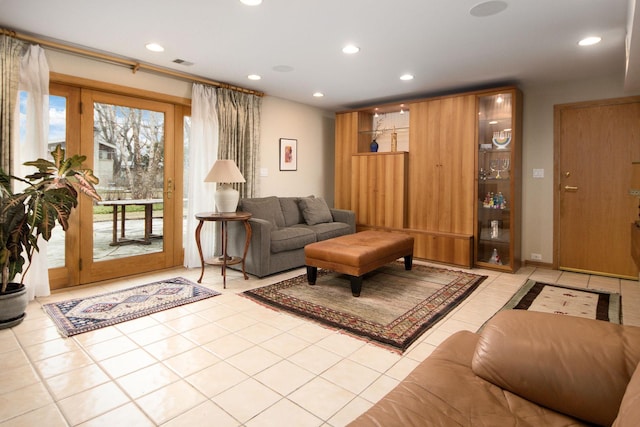 living room with a wealth of natural light, light tile patterned flooring, visible vents, and recessed lighting