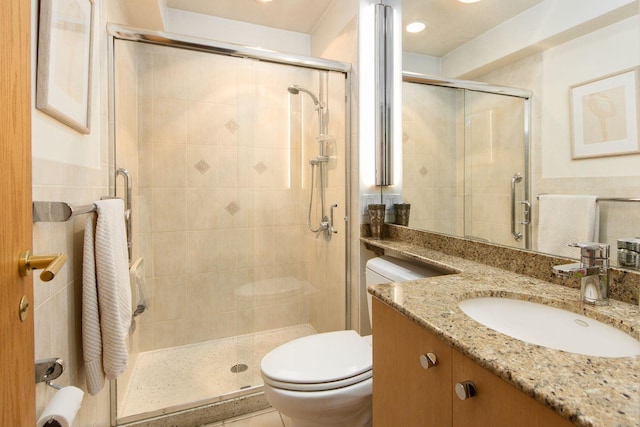 full bath featuring toilet, a stall shower, and vanity