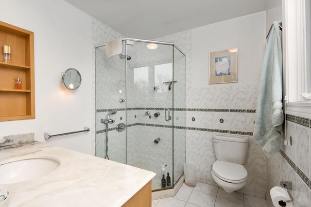 full bathroom featuring tile walls, toilet, a stall shower, vanity, and tile patterned flooring