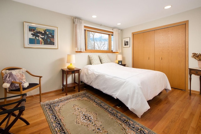 bedroom featuring baseboards, a closet, wood finished floors, and recessed lighting