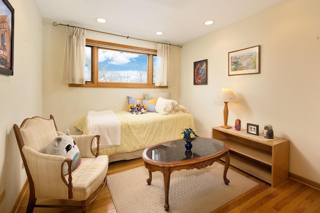 sitting room with baseboards, wood finished floors, and recessed lighting