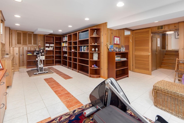 exercise room featuring wood walls, light tile patterned flooring, visible vents, and recessed lighting