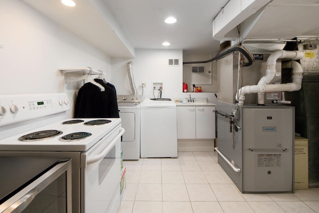 kitchen with light tile patterned floors, separate washer and dryer, visible vents, white cabinets, and white range with electric cooktop