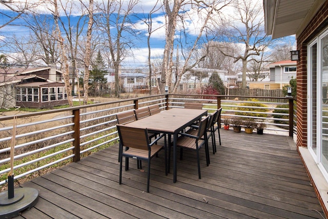 wooden deck with a residential view and outdoor dining area