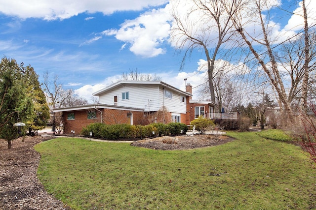 view of property exterior with a yard, a chimney, and brick siding