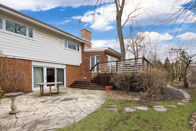 back of property with a patio area, a chimney, and brick siding