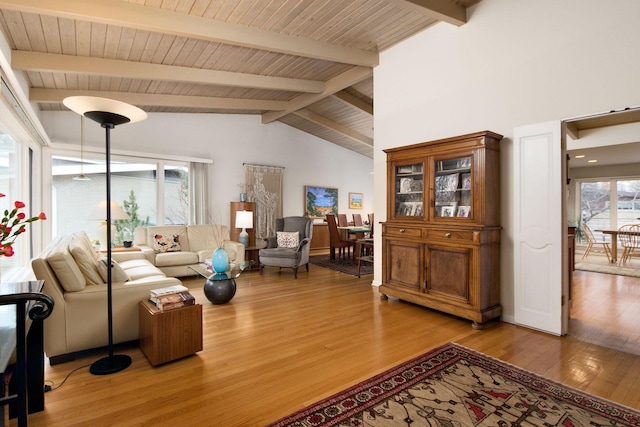 living room with light wood-style floors, wooden ceiling, and lofted ceiling with beams