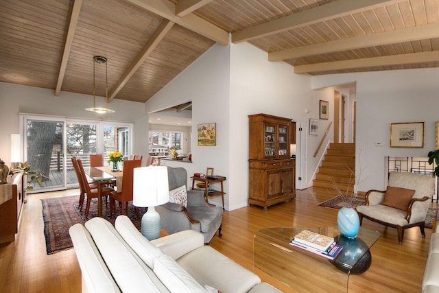 living room with stairway, wood finished floors, and beam ceiling