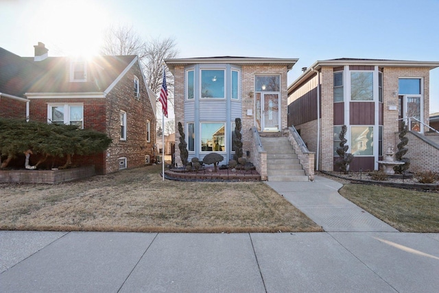 view of front facade with a front lawn and brick siding