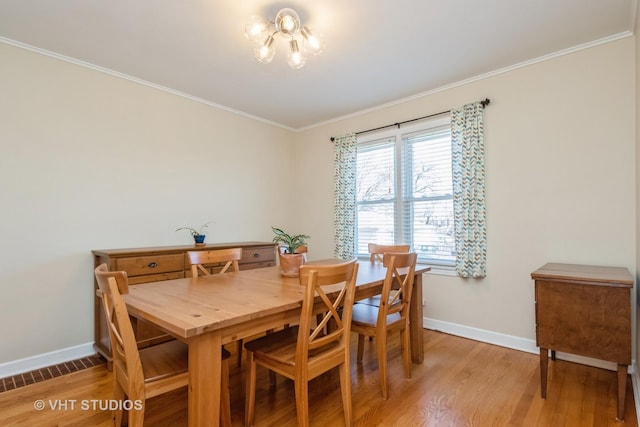 dining area with visible vents, baseboards, ornamental molding, and light wood finished floors