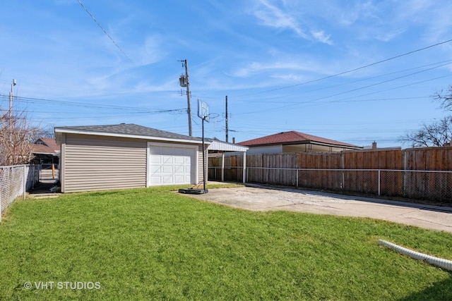 view of yard with a patio area, concrete driveway, a garage, a fenced backyard, and an outbuilding