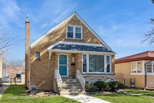 view of front of home featuring roof with shingles, a chimney, entry steps, stone siding, and brick siding