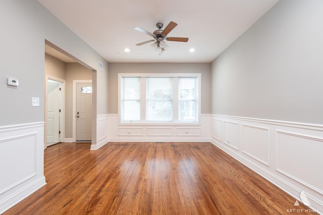 empty room with ceiling fan, recessed lighting, a wainscoted wall, wood finished floors, and visible vents