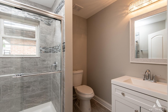 bathroom with toilet, a stall shower, vanity, and visible vents