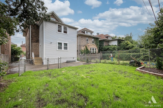 rear view of house featuring a fenced backyard and a yard