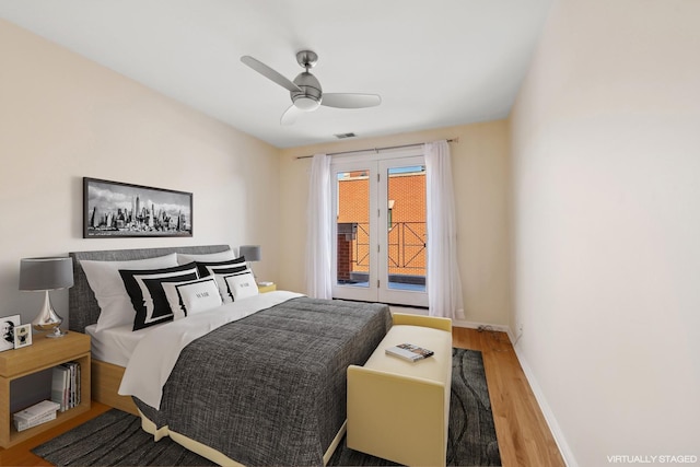 bedroom with visible vents, baseboards, a ceiling fan, wood finished floors, and access to outside