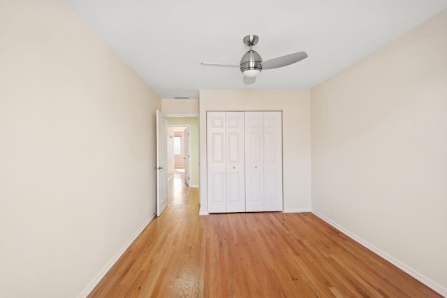 unfurnished bedroom featuring visible vents, baseboards, ceiling fan, light wood-type flooring, and a closet