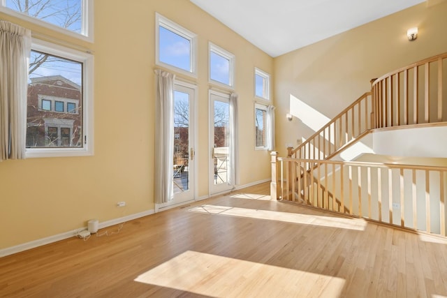 interior space featuring a high ceiling, wood finished floors, and baseboards