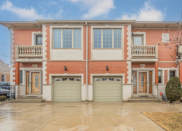 view of property featuring driveway, an attached garage, and brick siding